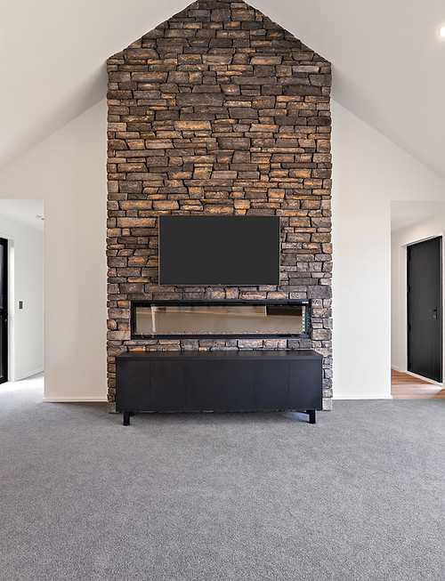 Lounge room in a single-storey home with brick feature wall and vaulted ceiling