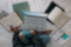 woman in blue long sleeve shirt and blue denim jeans sitting on bed using macbook_edited.j