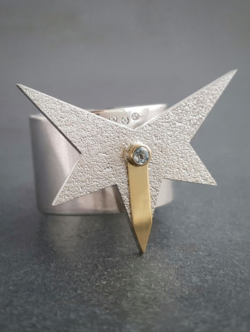 This beautifully bold ring from jeweller Natalia McIntosh features an asymmetric star with 18 carat gold stripe running through the middle, a single aquamarine and three moissanites. 