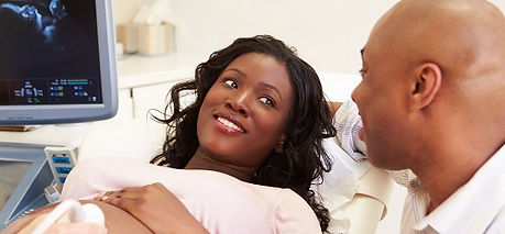 Woman receiving ultrasound smiling at her male partner