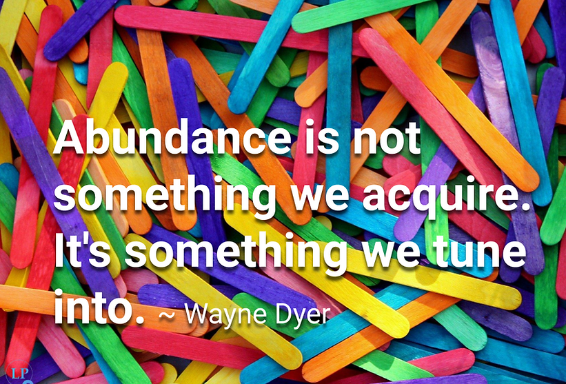 Quotepic Wayne Dyer on abundance set on a bed of colorful popsicle sticks all askew
