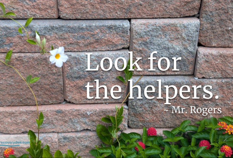 Quotepic Mister Rogers on helpers set next to a single white flower against a brick wall