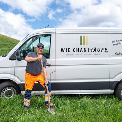 Michael Roos mit Spaten vor dem Wie Chani Häufe Bus auf der Wiese – tatkräftige Manpower im Einsatz