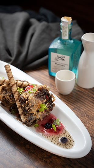 Delicious dish with crispy wafer garnish, small ceramic sake cup and bottle