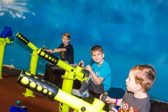 two kids have fun playing with ball blasters in Ball Blaster Arena at Ball Factory Naperville