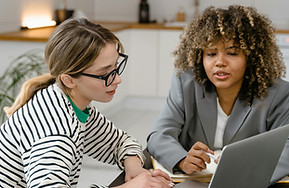 two women working a laptop