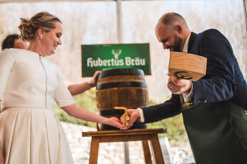 Das Brautpaar schlägt das Bierfass an