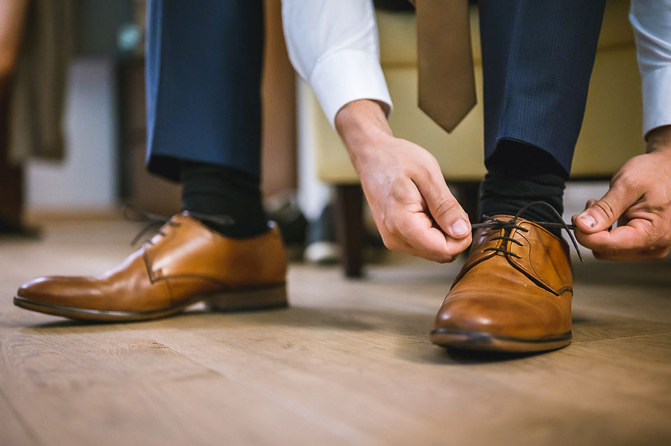 Bräutigam zieht sich Schuhe an im Berghotel Tulbinger Kogel 
