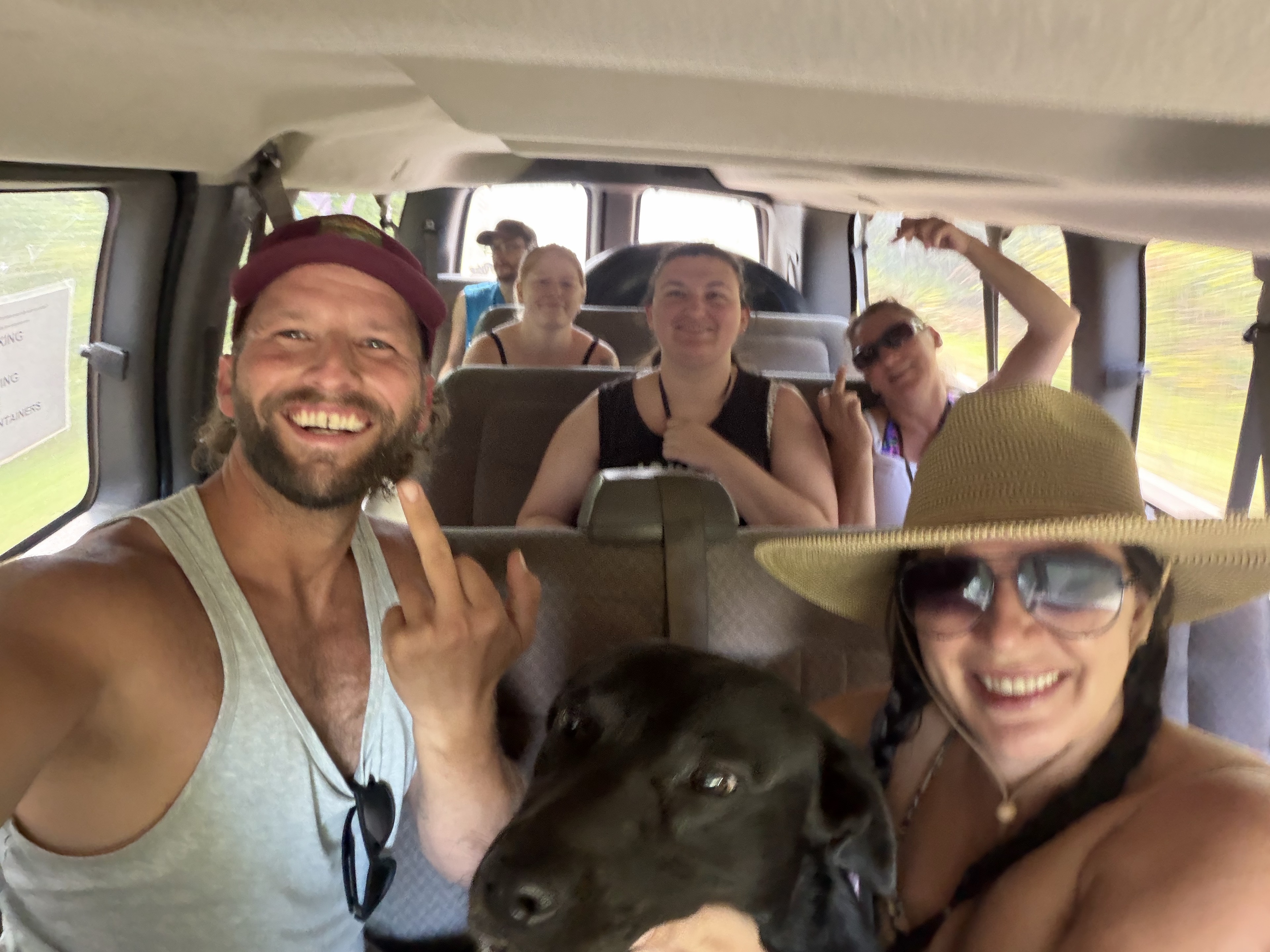 Dustin and the float crew riding together in a van, with a black dog in the foreground.