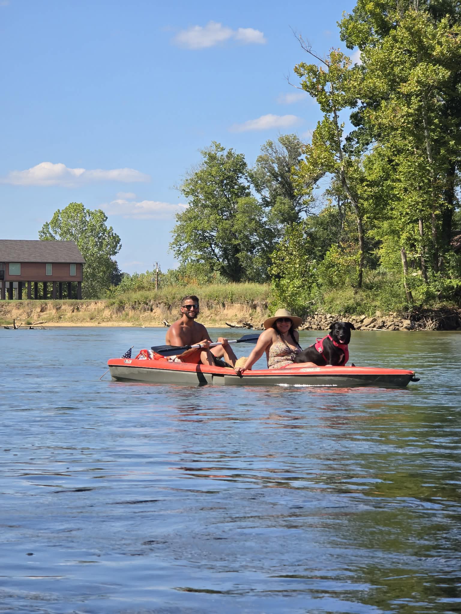 Two paddlers and a dog in a kayak on the Current River.