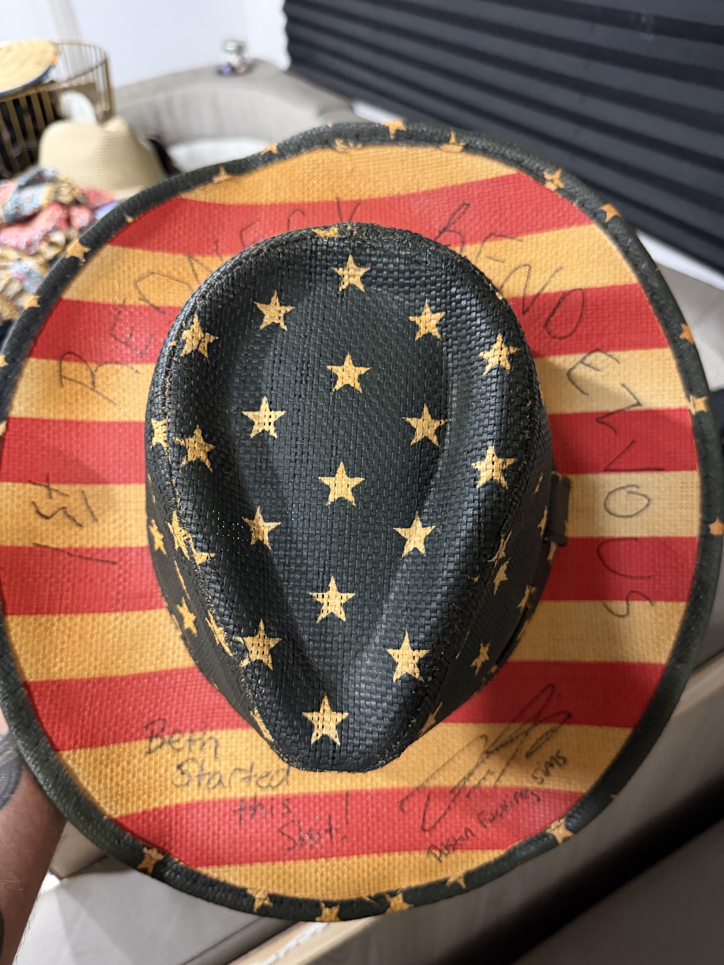 The stars-and-stripes hat Dustin gave Beth, inscribed “Beth started this shit.”