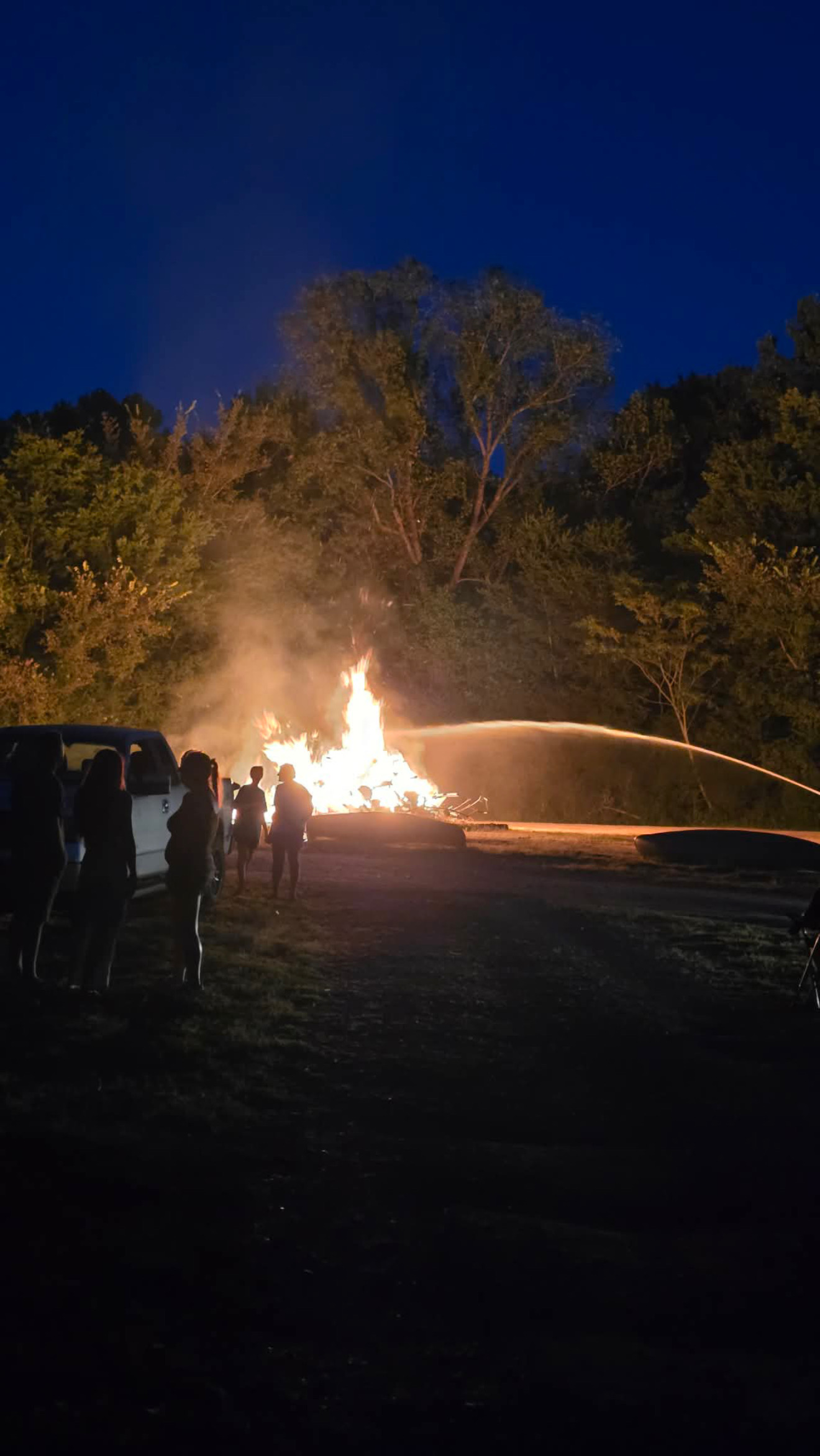 The Rendezvous Eve bonfire with people gathered nearby.