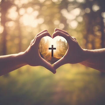 Hands in a heart shape with a cross in the center blurred nature background.jpg