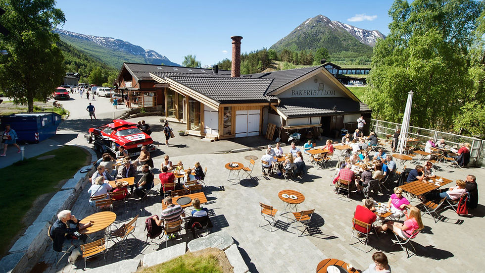 The outdoor seating at the bakery in Lom. Many people gathered at small tables in the brilliant sunshine.
