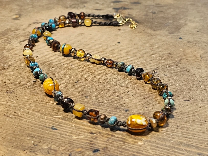 שרשרת ענברים וטורקיז ארוגה בחוטי שעווה בגוון קפה עשויה שילוב של ענברים שונים ואבני טורקיז