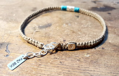 צמיד רגל ארוג בגוון קפה בהיר וטורקיז,משולב סנטר אלמנט בסגנון עתיק עשוי כסף 925  ובסוף הצמיד חרוז כסף מרובע יצוק עם ריקוע של א