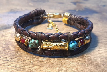 צמיד עור איכותי בגוון חום בצורת צמה בשילוב אריגת חוטים מיוחדת  וכדורי גולדפילד,אבני טורקיז טבעיות,גרנט,רינגים טופגולד(ציפוי ז