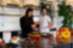 man and a woman standing in front of a table