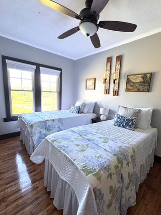 Piper’s Point bedroom with two twin beds and a private door to a shared bathroom at Rock Creek Venue.