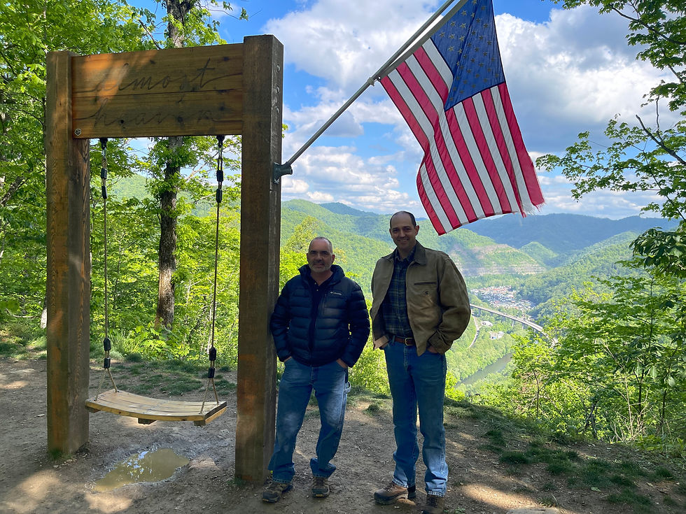 Justice Titus (right) and Mayor Fekete (left) standing at the Almost Heaven Swing overlooking the Town of Man below.