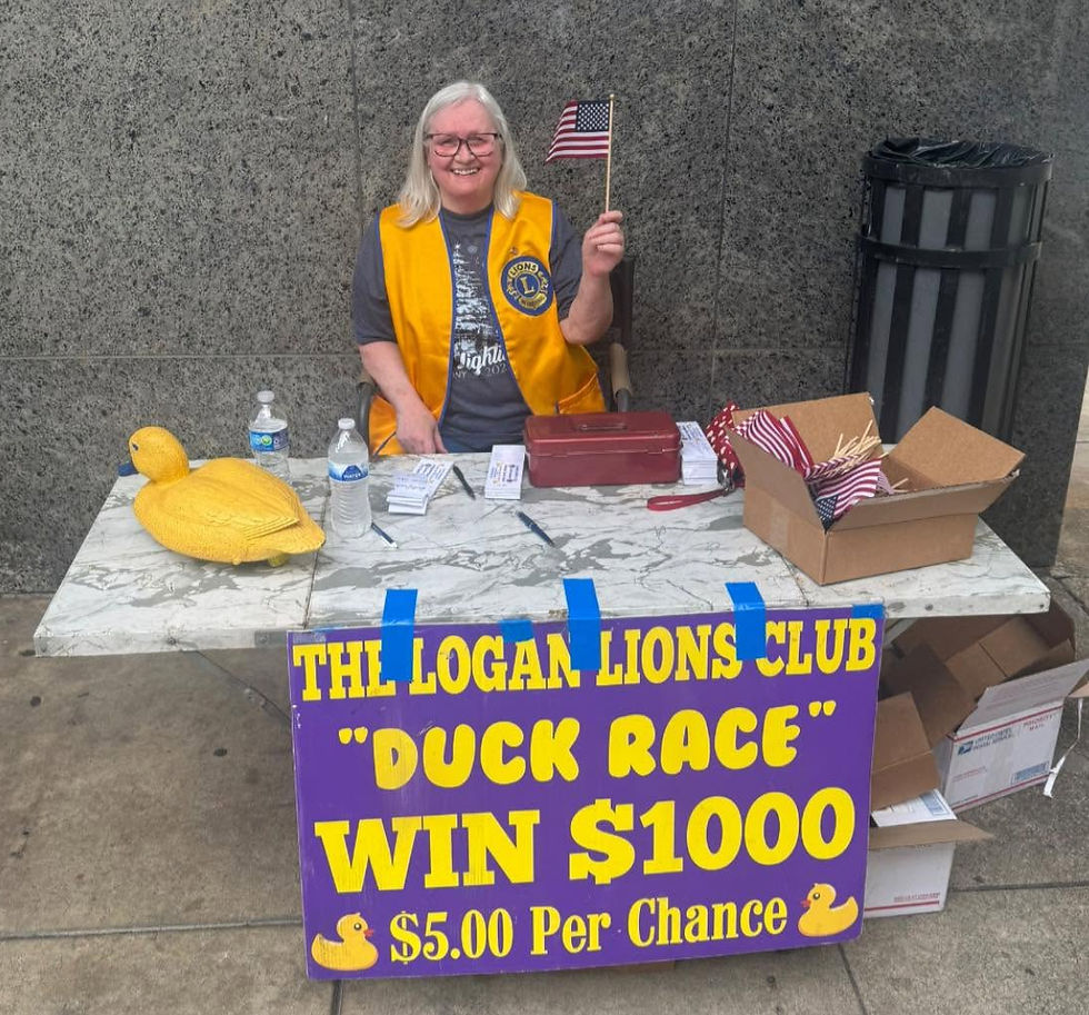 Logan Lions Club members set up at the Logan County Courthouse to give out American flags and sell tickets for the 23rd Annual Duck Race.