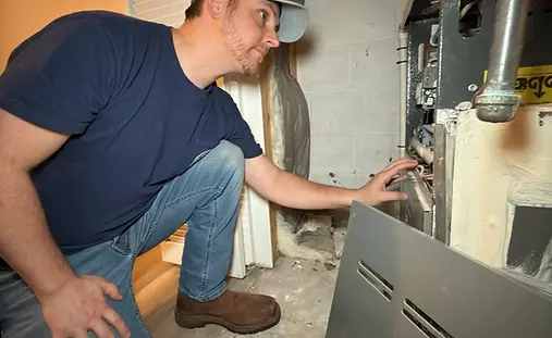 Home inspector checking the condition of a furnace during a property inspection.