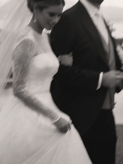 Fotografía editorial en blanco y negro con efecto de movimiento del novio ajustándose el traje de alta costura.