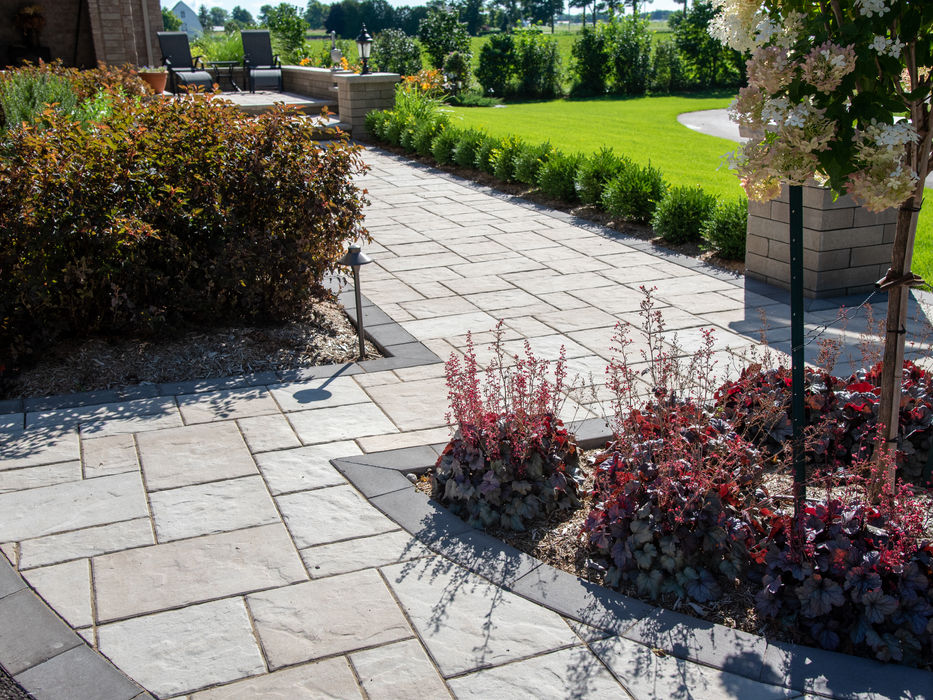 Detailed view of Unilock Beacon Hill pavers in Tuscany with a dark charcoal border, showcasing the textured finish and professional interlock installation.