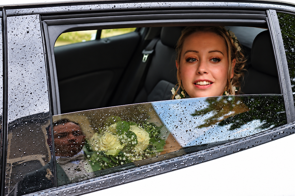 Mariée souriante derrière la vitre pluvieuse.png