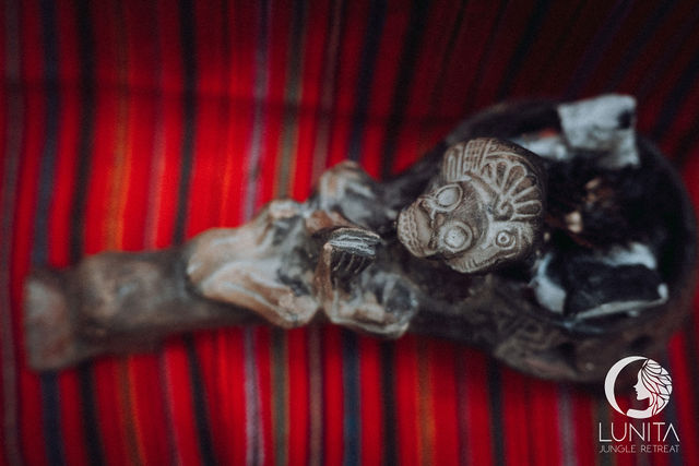 Ancient sculpture showcased on a vibrant woven textile at Lunita Jungle Retreat Center, Riviera Maya, Mexico.