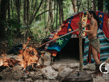 A participant engages in a traditional temazcal ceremony at the Lunita Jungle Retreat Center in Mexico, surrounded by the lush forest setting and vibrant textiles.