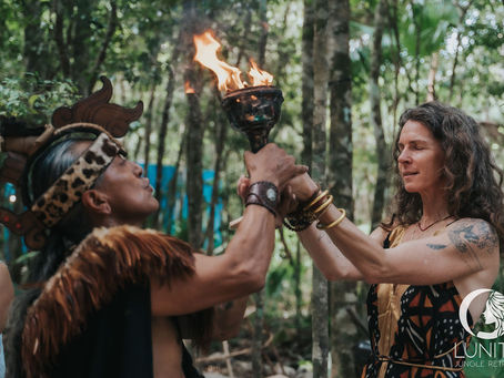A sacred moment unfolds during a 2025 blessing ceremony at Lunita Jungle Retreat in Mexico, as participants engage in a spiritual fire ritual surrounded by the lush forest.