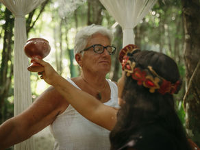 A participant engages in a traditional smudging ceremony at Lunita Jungle Retreat Center in Mexico, surrounded by lush greenery.
