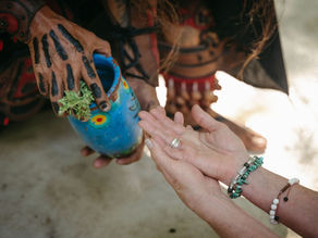 Participants engage in an ancestral healing ceremony at the Lunita Jungle Retreat Center in the Riviera Maya, Mexico, exchanging sacred herbs as part of the ritual.