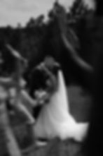 Bride and groom sharing a kiss, wedding guests cheering