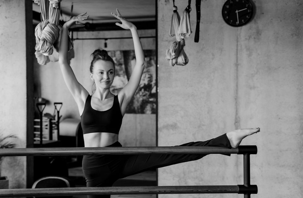 Woman in fitness wear practicing barre leg stretches