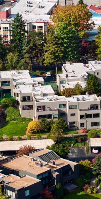 Aerial view of modern residential buildings with green lawns and trees
