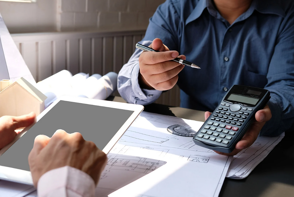 Two architects reviewing blueprints, using tablet and calculator