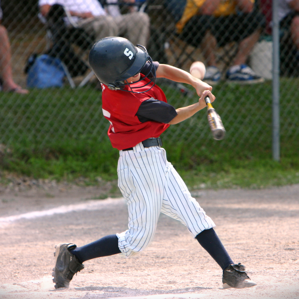 Young baseball player swinging a bat