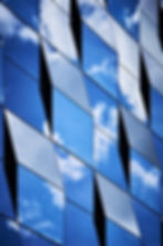 Abstract architecture modern building with diamond shaped windows reflecting blue sky