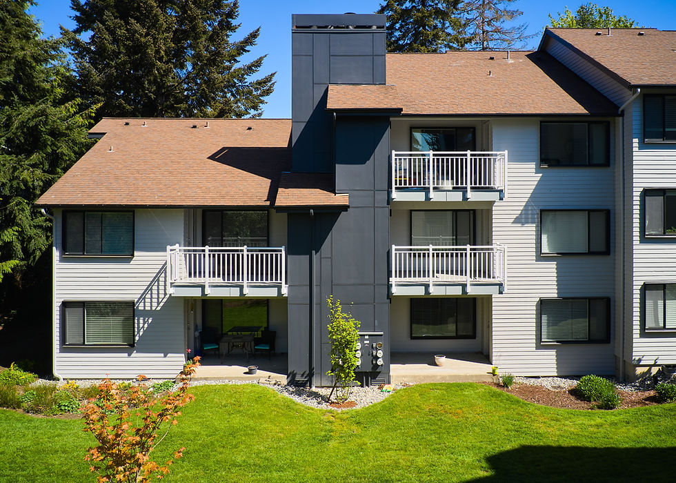 Exterior view of a modern apartment building with white balconies and green lawn
