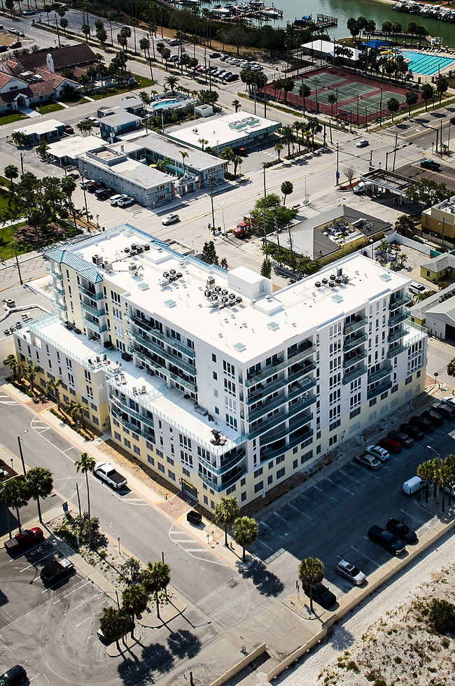 Aerial view of a white, multi-story building near other structures.