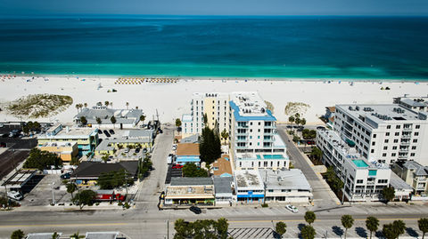 Aerial view of a beach with buildings and ocean in the background.
