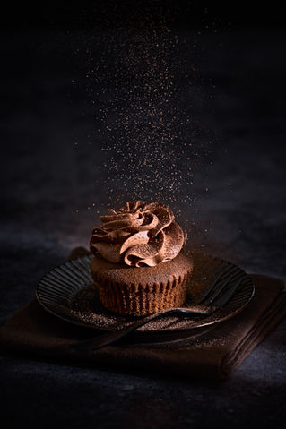 Schokoladenküchlein mit Topping auf schwarzem Hintergrund, perfekt für Dessert-Rezepte