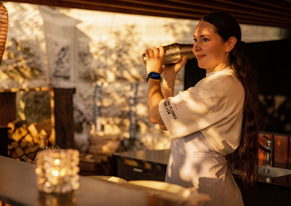Barkeeperin mixt einen Cocktail mit Shaker