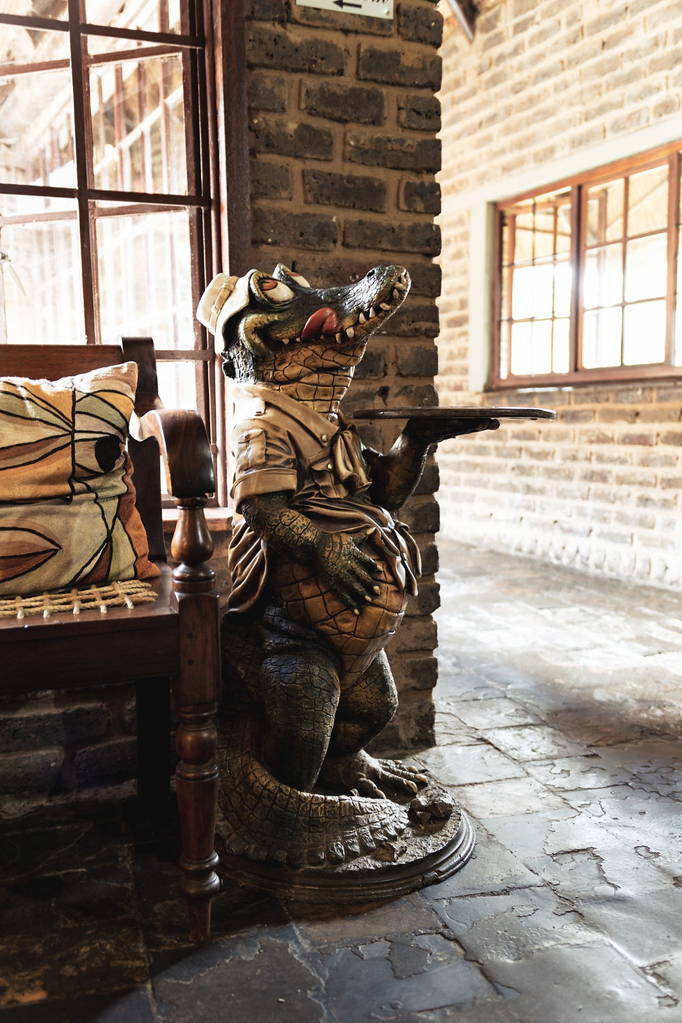 Crocodilian Hotel interior with decorative crocodile statue in rustic brick setting Fochville