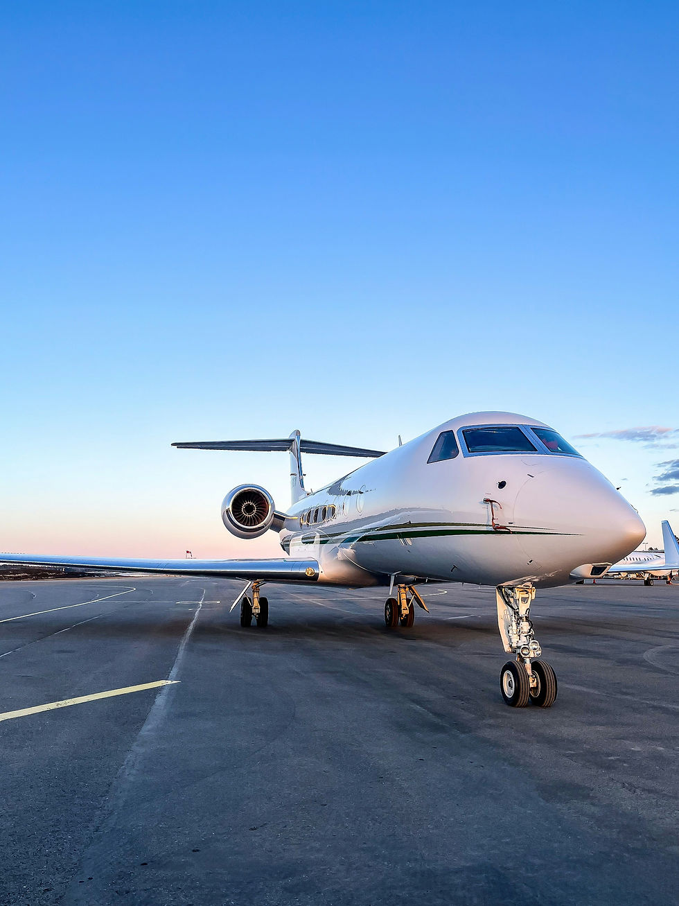 Gulfstream G550 Private jet parked on the tarmac during sunset with a clear blue sky