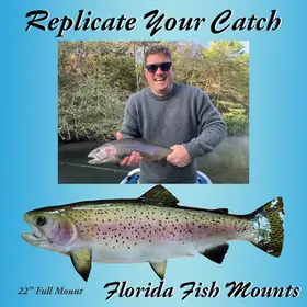 Angler holding a real 22-inch rainbow trout next to a fiberglass fish mount replica painted by Greg Cassell.