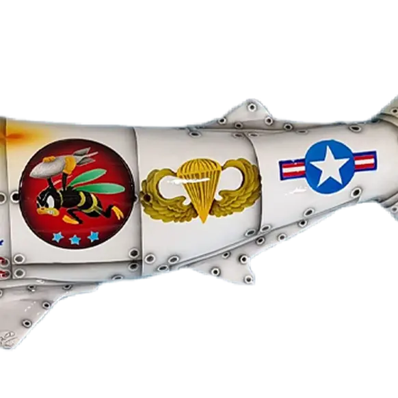 Close-up of military emblems on hammerhead shark mount including bumblebee badge, parachutist wings, and USAF roundel.