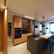 Open space moderno con finiture in legno naturale e dettagli in nero, mobili di design